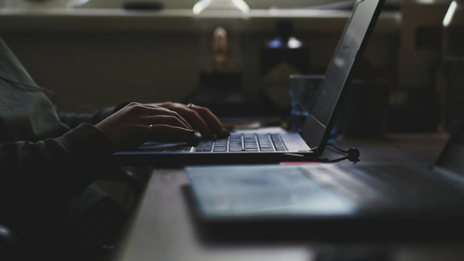 A laptop on a desk by a window