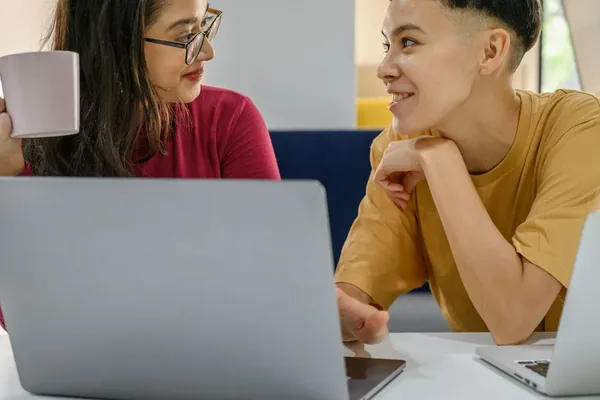 Two colleagues talking over a laptop