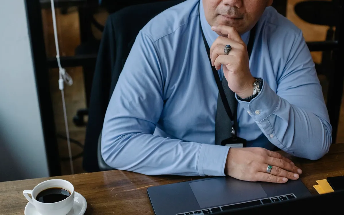 A business owner pausing at a desk, thinking through a problem