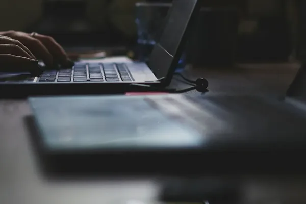 Hands typing on a laptop